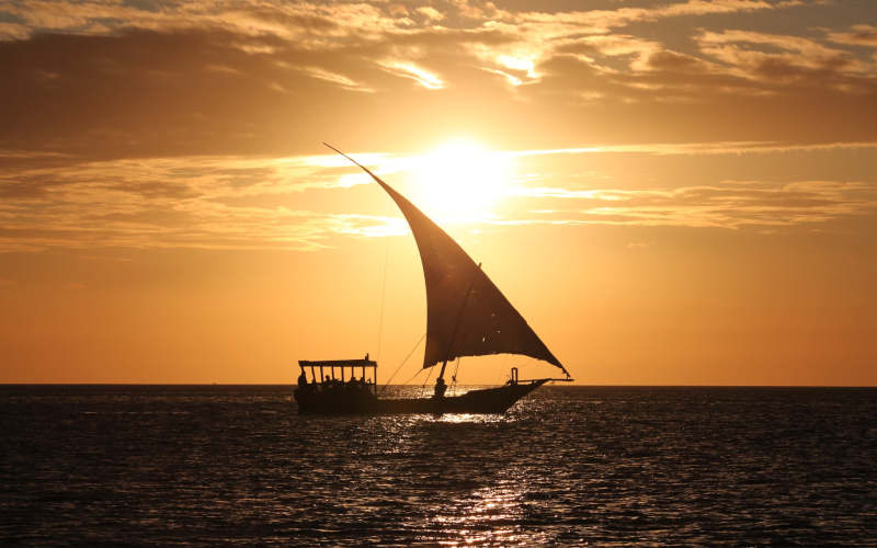 Voilier voguant sur fond de coucher de soleil.